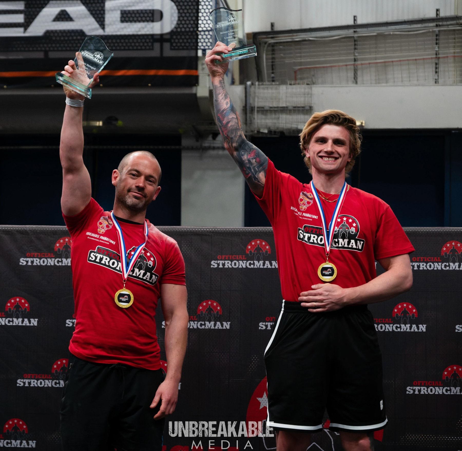 Two strongman medallists celebrating at a competition